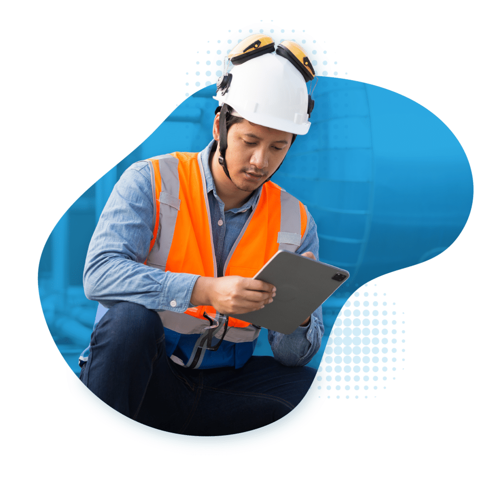 Hero image of a man in an orange worker vest crouching down and holding a tablet, representing the energy and utilities industry