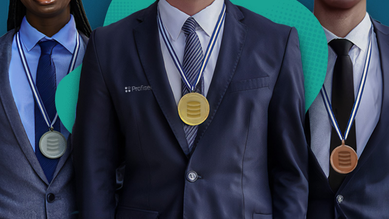 Three men in suits stand side by side with bronze, silver, and gold medals hanging from their necks.