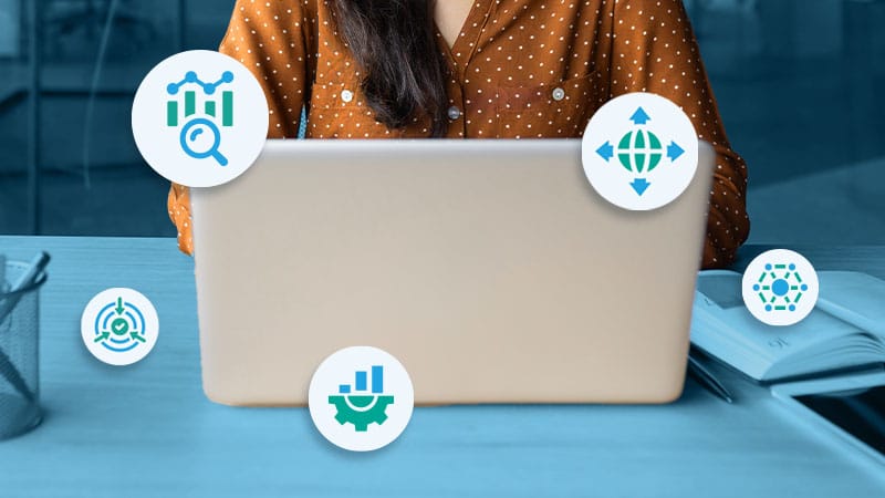 A data professional works on a laptop while icons representing different aspects of MDM frameworks float in the foreground.