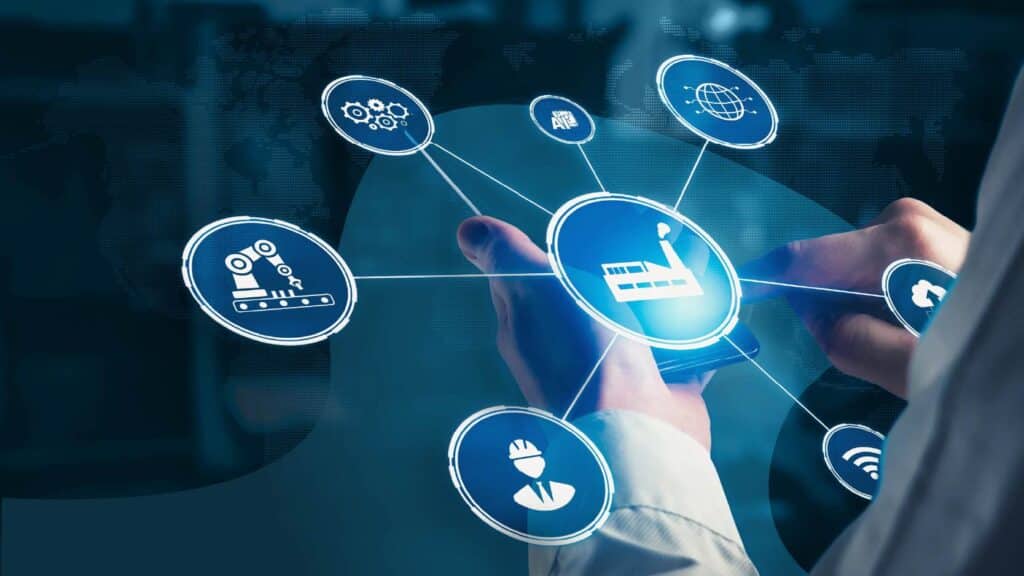 A knowledge worker holds a device projecting a hologram of different icons representing different aspects of the supply chain.