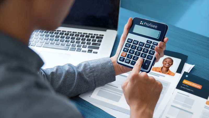 Picture of a person performing calculations on a Profisee-branded calculator.