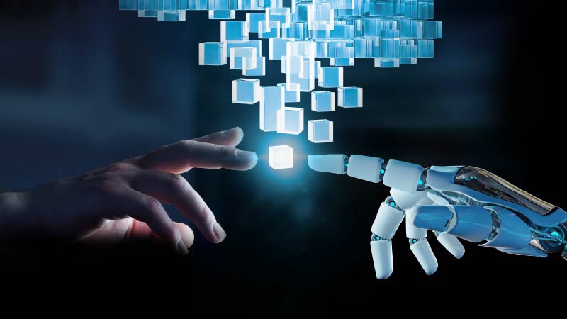Image of a human and a robotic hand about to touch with glowing blue data cubes coming between the two.